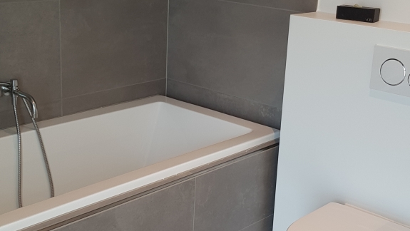 Flisearbejde i badeværelse med badekar og vægfliser i Spøttrup