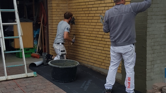 Vandskuring af hus på Mors med håndpudsning af mur