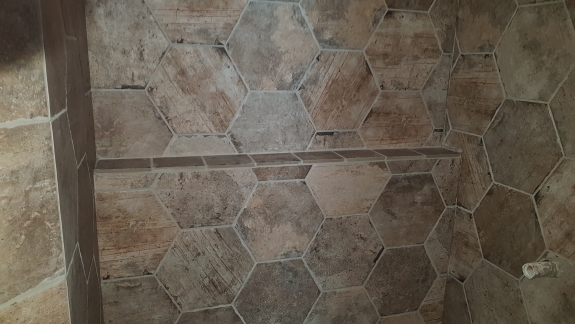 Flisearbejde i bruseniche med sekskantede fliser og hylde i Skive