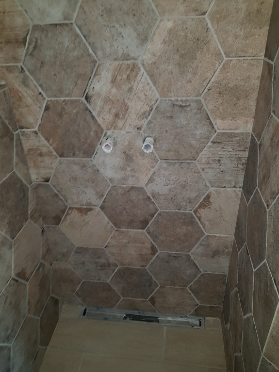 Flisearbejde med rustikke sekskantede fliser i bruseniche i Skive