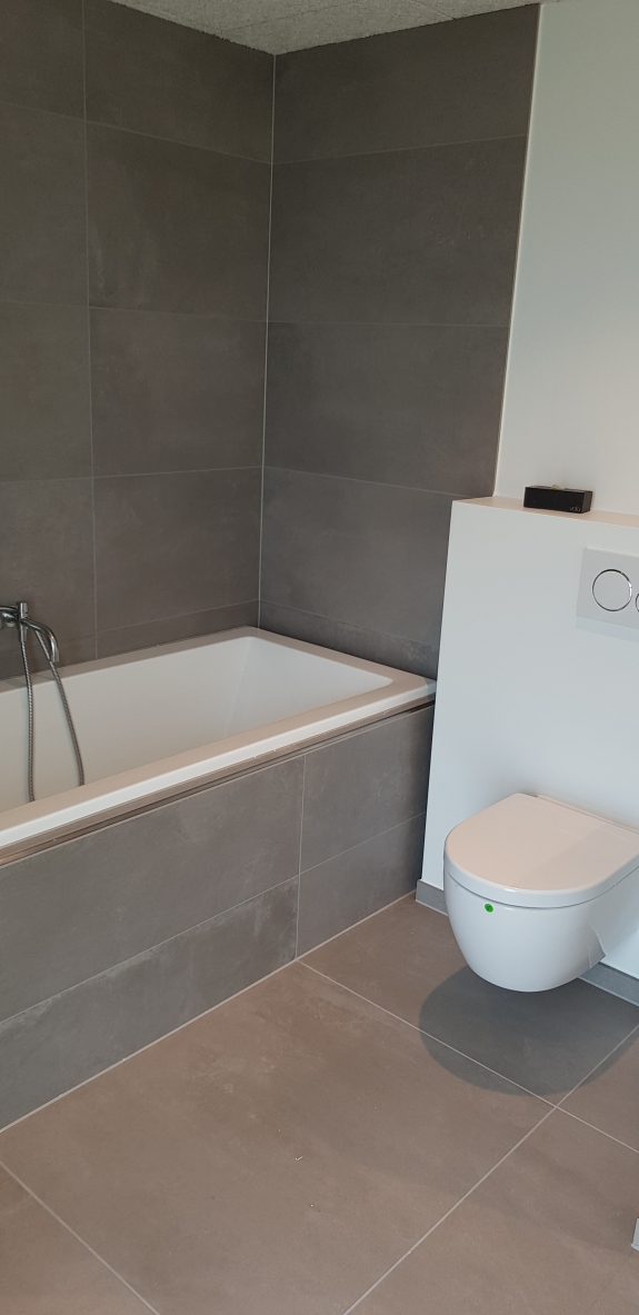 Flisearbejde i badeværelse med badekar og vægfliser i Spøttrup